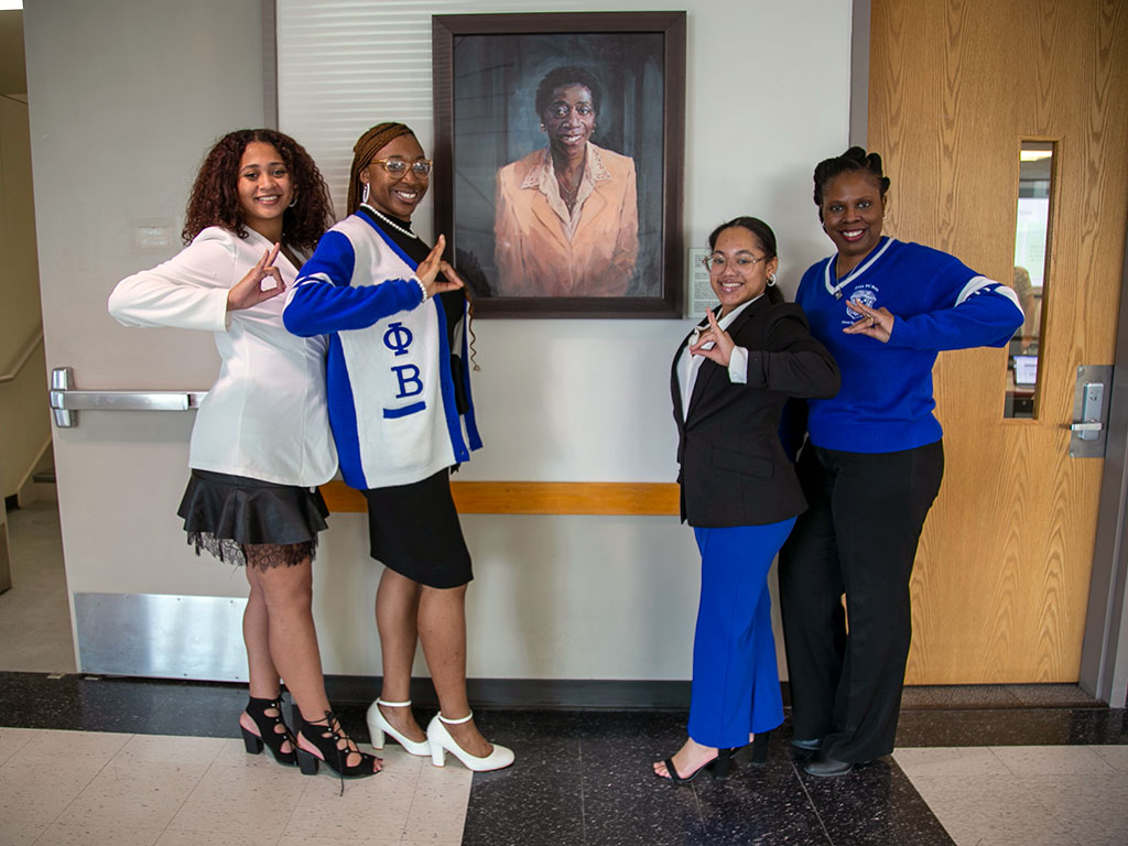 Members of Zeta Phi Beta pose with the newly-installed portrait of Martha Dawson