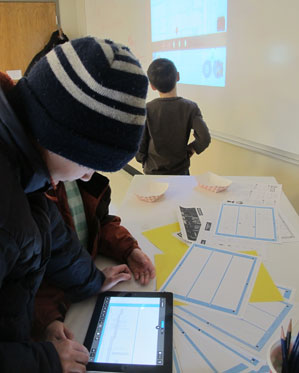 A student looking over game design on an iPad during the Saturday Art showcase show, Dec. 6, 2014.