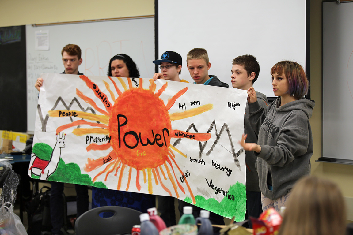 students holding a banner they painted
