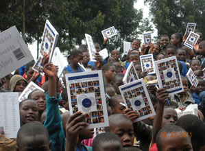 Rwandan students hold up copies of a previous edition of "The World Is Our Home" during a Books and Beyond visit in June 2011. | Photo by Books and Beyond