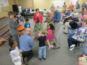 Gus Weltsek (kneeling in blue shirt) leads Fairview students in a song game they created. Across the circle in the red sweater is IU art education master's student Samantha Petry.