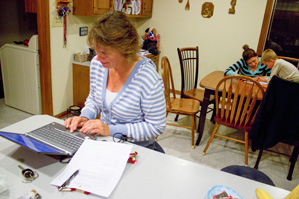 A mother and children homeschooling in a kitchen